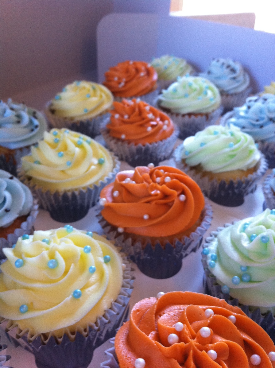 Orange, yellow, blue, green baby shower cupcakes