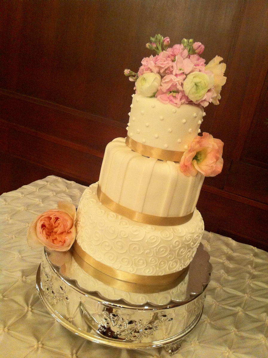 "Miranda" Ivory wedding cake with ivory accents and champagne ribbon border on silver cake stand